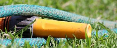 Gartenbewaesserung – Schlauch liegt im Rasen