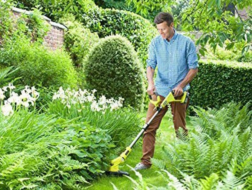 Mann trimmt Rasenkanten im Garten mit Akku-Rasentrimmer