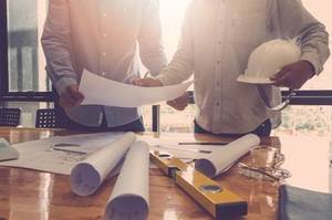 Männer in Architekturbüro mit Plänen