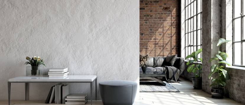 Modernes Loft mit einer Betonwand vor einem abgetrennten Wohnbereich.