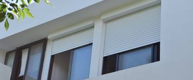 Helle Rolläden an einem Fenster.