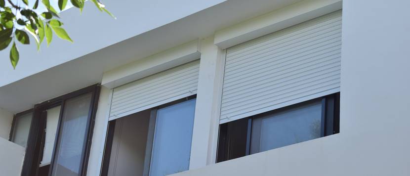 Helle Rolläden an einem Fenster.
