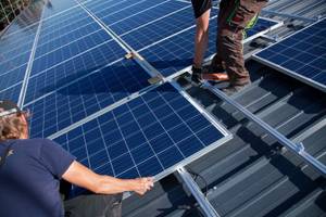 arbeiter installieren pv-module auf dach