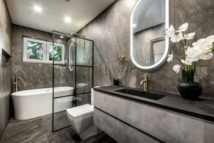 Ein Badezimmer in moderner grauer Optik liegt im Kellergeschoss.