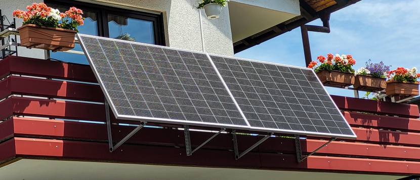 Zwei Solarmodule sind an einem Balkon in einem bestimmten Winkel montiert.