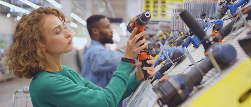 Frau schaut sich Bohrer im Laden an.