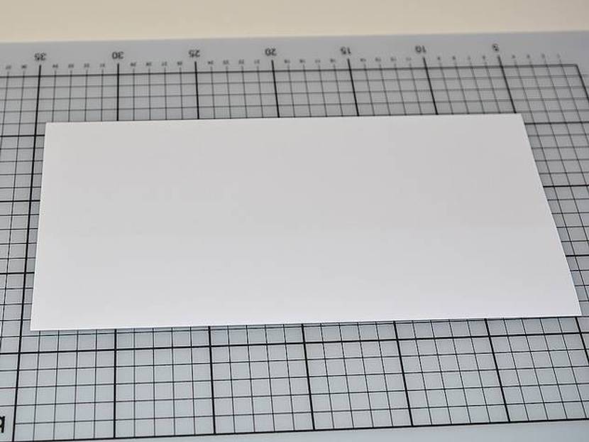 Den Papierbogen mittig falten.