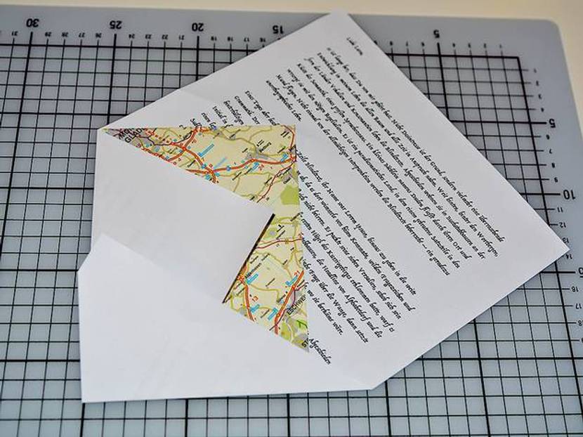 Den DIN A6 Umschlag mit einer Ecke, wie auf dem Bild zu sehen, auf den Briefbogen legen und die ersten beiden Ecken umschlagen. Der Winkel, in dem der Umschlag auf das Papier gelegt wird, kann frei gewählt werden.