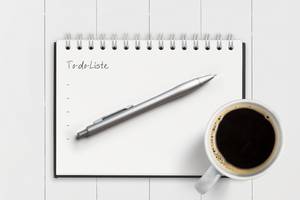 Ausmisten: Checkliste mit Stift und Kaffee.
