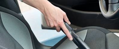 Autoinnenreinigung (Original Titel: Man hoovering a car cabin) [beschnitten]