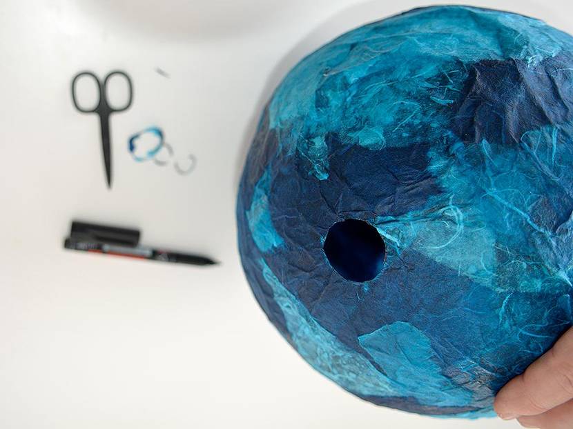 Mit einer Schere werden vorsichtig die notwendigen Öffnungen in den Ballon geschnitten.