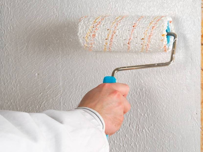 Kleister mit der Rolle auf die Wand auftragen