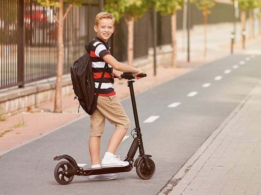 Kind steht auf elektro-scooter