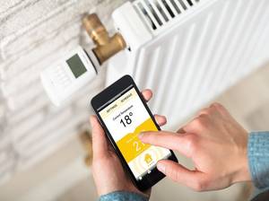 Person Adjusting Temperature Of Radiator On Cell Phone