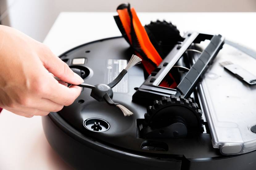 Eine Person baut einzelne Komponenten eines Staubsaugerroboters zusammen.