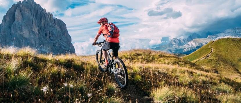Fahrradhosen für Herren im Test: Mountainbiker steht auf mit seinem Fahrrad auf einem Berggipfel.