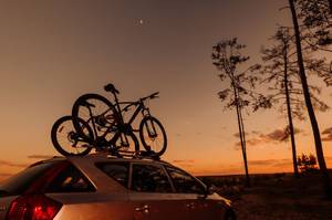 Fahrräder auf Dachträger eines Autos in der Natur mit Abendhimmel