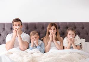 Familie mit Allergie im Bett