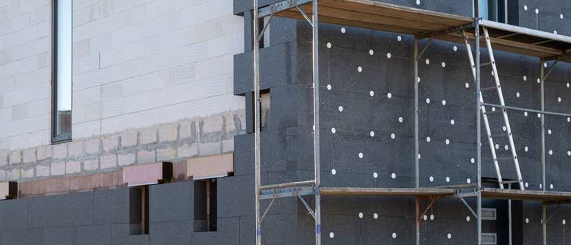 Eine halb gedämmte Fassade eines Hauses.