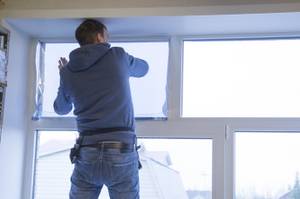 Mann beim Anbringen von Fensterfolie