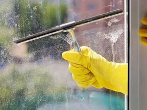 Mann entfernt Kleber von Fensterfolie