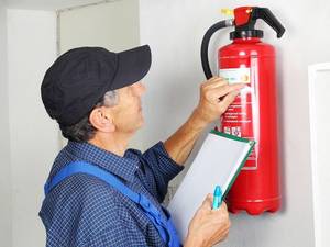 Mann in Uniform wartet Feuerlöscher