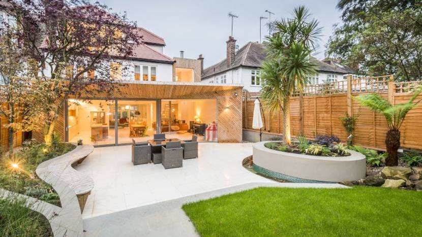 Ein moderner Garten setzt nur wenige Elemente ein: Etwa ein Holz-Gartenhaus, gute Beleuchtung, Beton und einige wenige Pflanzen.