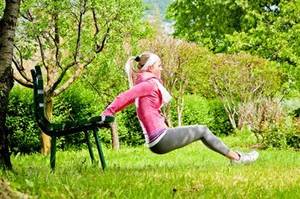 Frau macht Dips an einer Gartenbank