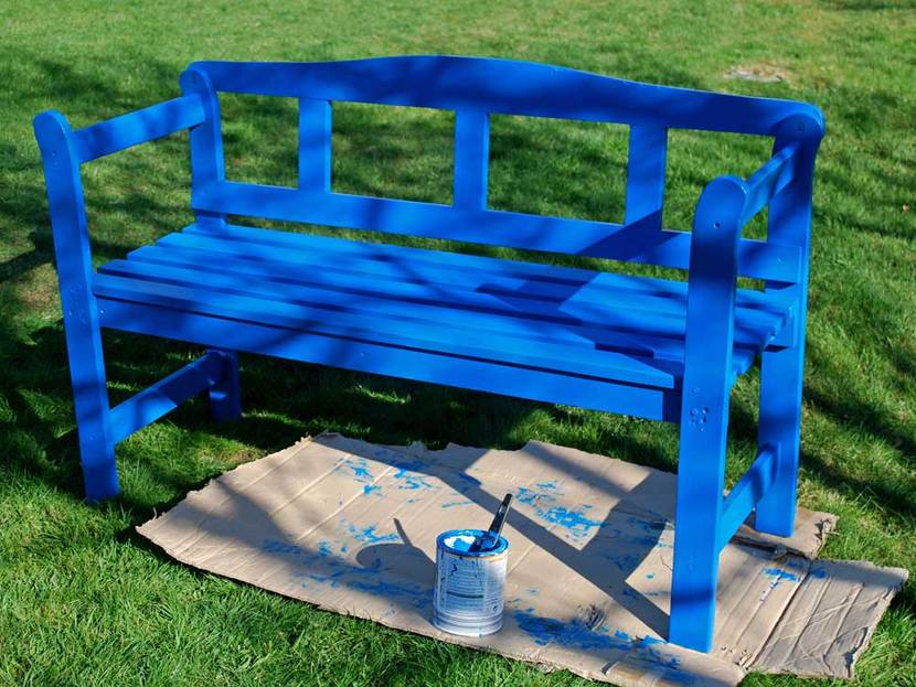blau lackierte Gartenbank auf dem Rasen