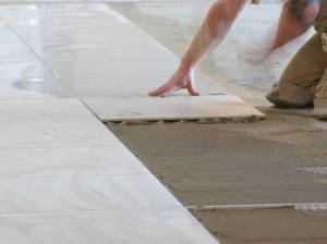 Fliesen und Boden mit Fliesenkleber versehen