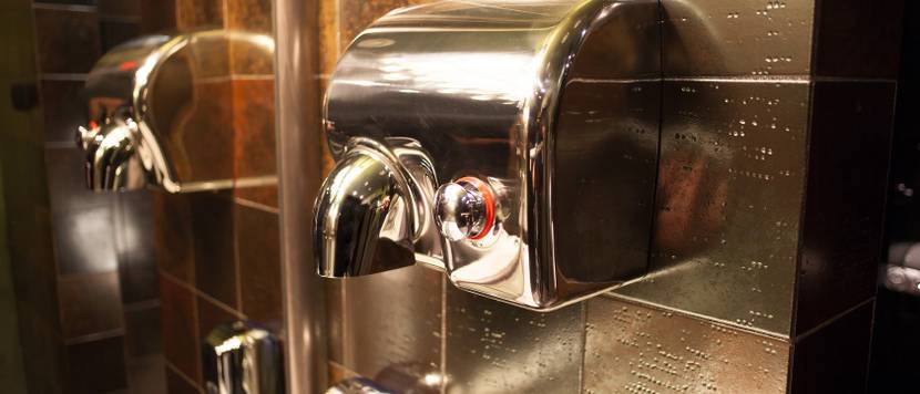 Metallischer Händetrockner mit Druckschalter.