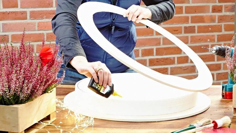 ür den Kranzrohling wird das Styropor zwischen die Holzringe geklebt