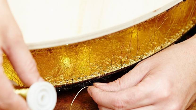 Damit die Lichter nicht herausfallen, wird die Ober- und Unterseite der Holzringe mit Golddraht zugenäht