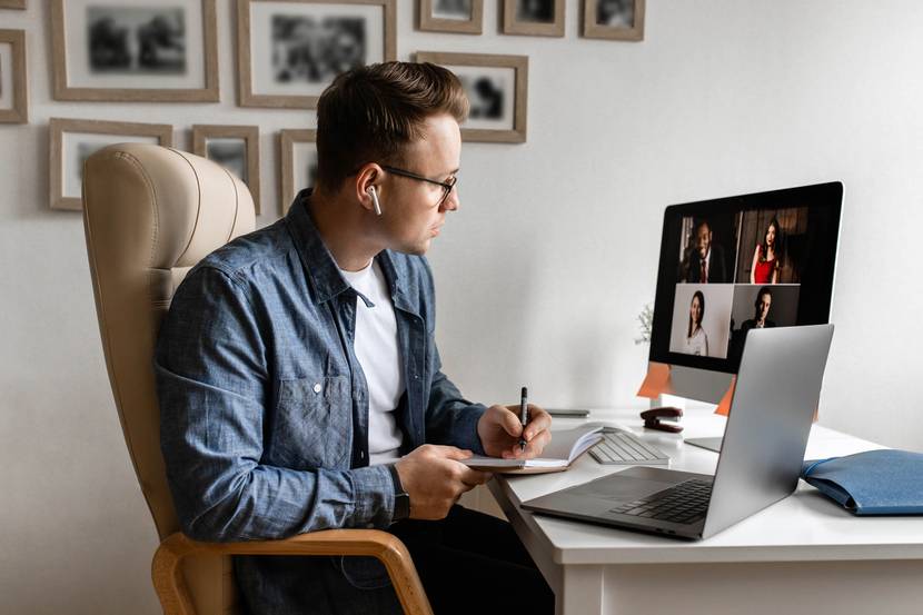 Ein Mann sitzt im Homeoffice in einer Videokonferenz.
