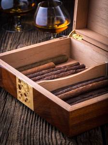 Humidor mit Zigarren und Cognac auf Holztisch