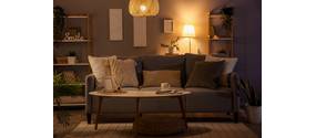 In einem modernen Wohnzimmer leuchtens abends verschiedene Lampen, die eine gemütliche Atmosphäre erzeugen.