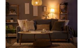 In einem modernen Wohnzimmer leuchtens abends verschiedene Lampen, die eine gemütliche Atmosphäre erzeugen.