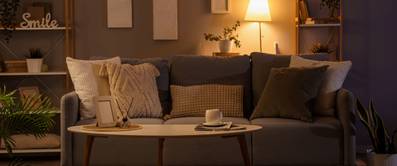 In einem modernen Wohnzimmer leuchtens abends verschiedene Lampen, die eine gemütliche Atmosphäre erzeugen.
