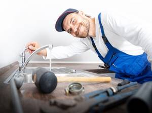 Installateur / Klempner positiv lächelnd bei der Arbeit