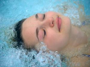 Junge Frau genießt einen Aufenthalt in einem Whirlpool