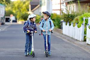 Zwei Jungen auf Cityrollern