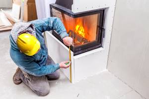 Mann installiert Kalziumsilikatplatten um einen Kamin