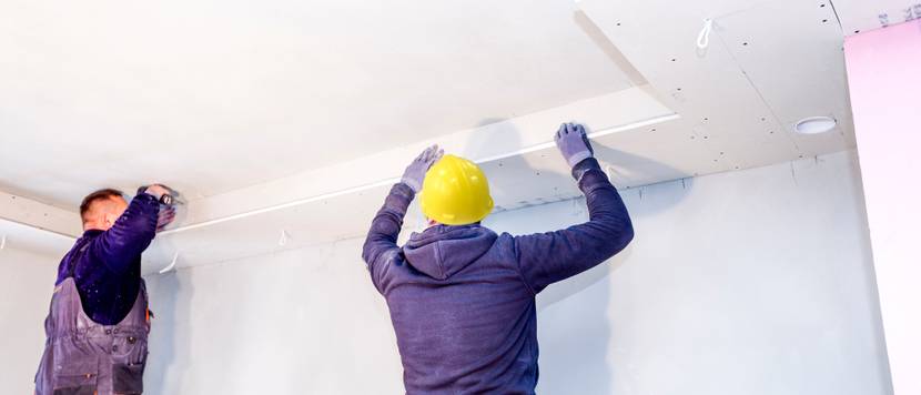Arbeiter bringen Kalziumsilikatplatten als Brandschutz an