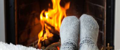 Kinderfüße in warmen Wollsocken, die im Kaminfeuer erhitzt wurden