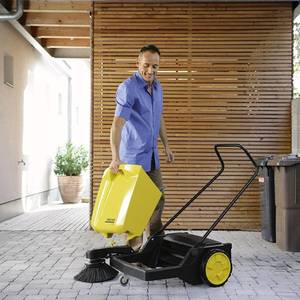 Mann hält Behälter der Kehrmaschine