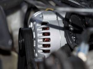 Ein Motor von einem Auto und Nahaufnahme der Lichtmaschine und Keilriemen
