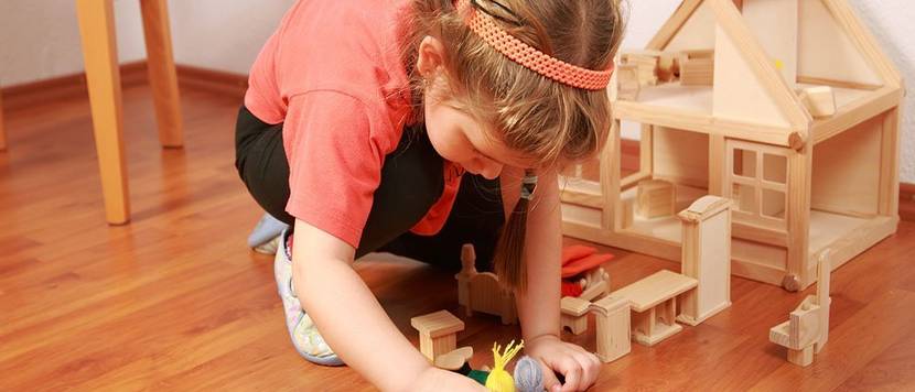 kind spielt mit puppenhaus
