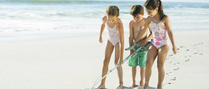 kinder mit metalldetektor am strand