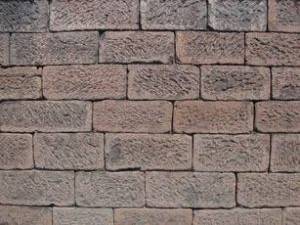 Eine Wand aus regelmäßíg behauenen Natursteinen.