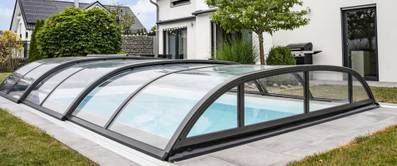 Poolüberdachung im Test: Poolabdeckung mit Halbkreisform über einem Außenpool.